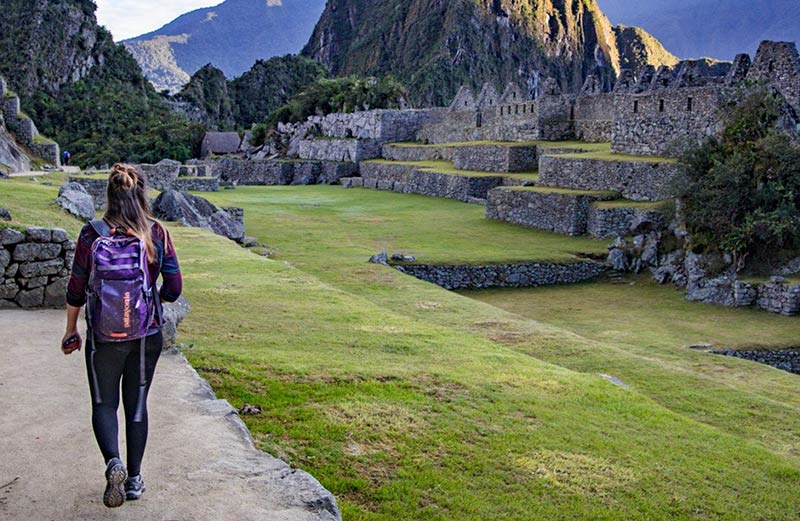 Turista recorriendo por el sitio arqueológico de Machu Picchu