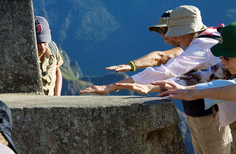Turistas sintiendo la energía de Machu Picchu